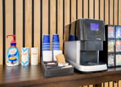 Thumbnail 43 of 95 - a coffee maker on a table with coffee cups and a napkin dispenser next at Presidio Palms Apartments, Arizona