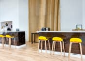 Thumbnail 41 of 95 - a bar with yellow bar stools in front of a counter with chairs at Presidio Palms Apartments, Tucson, Arizona