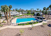 Thumbnail 70 of 95 - A pool surrounded by palm trees and a fence at Presidio Palms Apartments, Arizona, 85701