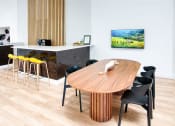 Thumbnail 49 of 95 - a dining room with a wooden table and black chairs at Presidio Palms Apartments, Tucson