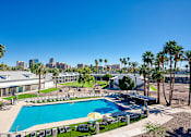 Thumbnail 80 of 95 - A pool surrounded by palm trees and a city skyline in the backgroundat Presidio Palms Apartments, Tucson