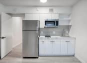 Thumbnail 28 of 95 - a kitchen with refrigerator and white cabinets at Presidio Palms Apartments, Tucson, AZ