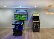 Thumbnail 67 of 95 - a living room with two video games and a tv at Presidio Palms Apartments, Tucson