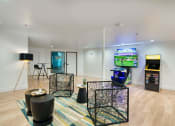 Thumbnail 65 of 95 - a living room with a tv and a video game on the wall at Presidio Palms Apartments, Tucson, AZ