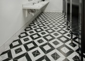 Thumbnail 69 of 95 - a bathroom with a black and white tiled floor and stalls at Presidio Palms Apartments, Arizona, 85701