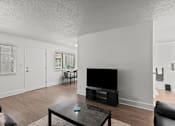 Thumbnail 13 of 28 - A living room with a black coffee table and a black television.