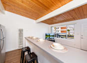Thumbnail 23 of 28 - A kitchen with a refrigerator, a counter, and a window at The Wave