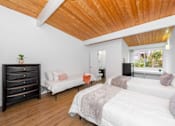 Thumbnail 27 of 28 - A bedroom with a white bed and a wooden ceiling.