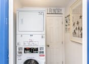 Thumbnail 28 of 28 - A washing machine in a laundry room with a door and a sign above it.