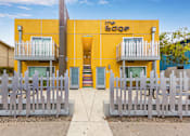 Thumbnail 19 of 28 - The Edge building has a yellow facade and white fences.