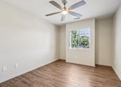 Thumbnail 51 of 54 - A room with a ceiling fan and wooden flooring.
