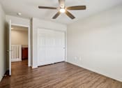 Thumbnail 50 of 54 - A bedroom with a ceiling fan and a white closet door.