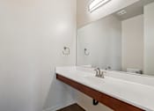Thumbnail 49 of 54 - A white sink in a bathroom with a mirror above it.