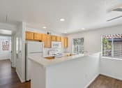 Thumbnail 23 of 33 - A kitchen with white appliances and wooden cabinets.