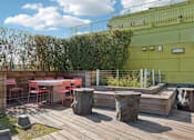 Thumbnail 6 of 31 - A wooden deck with a table and chairs.