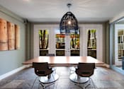 Thumbnail 6 of 28 - A dining room with a wooden table and chairs.