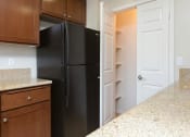 Thumbnail 29 of 38 - a kitchen with dark cabinets and black appliances