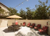 Thumbnail 13 of 38 - a patio with blue chairs and an umbrella