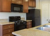 Thumbnail 28 of 38 - a kitchen with dark cabinets and black appliances