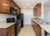 Thumbnail 27 of 38 - a kitchen with dark cabinets and black appliances