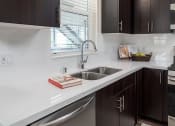 Thumbnail 22 of 25 - a kitchen with dark cabinets and stainless steel appliances