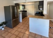Thumbnail 34 of 46 - a kitchen with a counter top and a refrigerator
