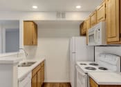 Thumbnail 34 of 61 - a kitchen with white appliances and wooden cabinets