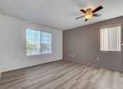 Thumbnail 49 of 61 - an empty living room with a ceiling fan and two windows