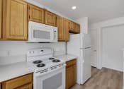 Thumbnail 55 of 61 - a kitchen with a white stove top oven next to a refrigerator