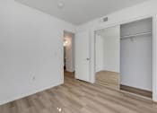 Thumbnail 60 of 61 - a bedroom with white walls and a wooden floor