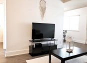 Thumbnail 26 of 46 - a living room with a television and a table
