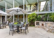 Thumbnail 8 of 46 - a patio with a table and chairs and a stone fireplace