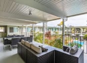 Thumbnail 7 of 46 - a covered patio with tables and chairs and a pool