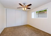 Thumbnail 15 of 16 - A bedroom with a ceiling fan and sliding closet doors.