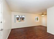 Thumbnail 13 of 16 - Living room with wood flooring and a ceiling fan.