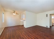 Thumbnail 12 of 16 - A living room with wood flooring and a ceiling fan.
