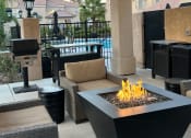Thumbnail 28 of 61 - a patio with a fire pit and seating around it