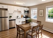 Thumbnail 1 of 14 - A kitchen with a table and chairs.