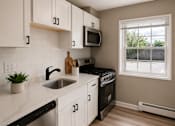 Thumbnail 3 of 14 - A kitchen with white cabinets and black countertops.
