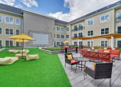 Thumbnail 29 of 80 - a courtyard with a lawn and tables and chairs