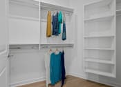 Thumbnail 50 of 61 - a walk in closet with white closet doors and clothes hanging on a rack