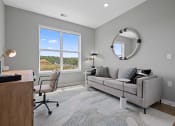 Thumbnail 54 of 61 - a living room with a couch and a desk with a window