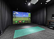 Thumbnail 31 of 70 - Golf simulation room with hitting mat and screen at Aster Grove Apartments, Warren, New Jersey