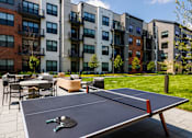 Thumbnail 43 of 70 - Outdoor courtyard with ping pong table and seating at Aster Grove Apartments, New Jersey