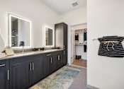 Thumbnail 51 of 61 - A bathroom with dark wood cabinets and a large mirror.