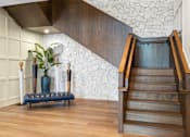 Thumbnail 4 of 61 - A staircase with wooden steps and a bench with a vase on it.