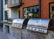 Thumbnail 34 of 61 - A brick building with a wall of grills in front.