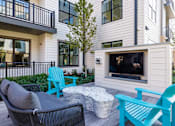 Thumbnail 38 of 61 - A modern outdoor living space with a television and seating area.
