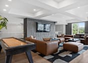 Thumbnail 21 of 61 - A modern living room with a pool table and leather furniture.