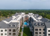 Thumbnail 60 of 61 - an aerial view of a large building with a pool and trees